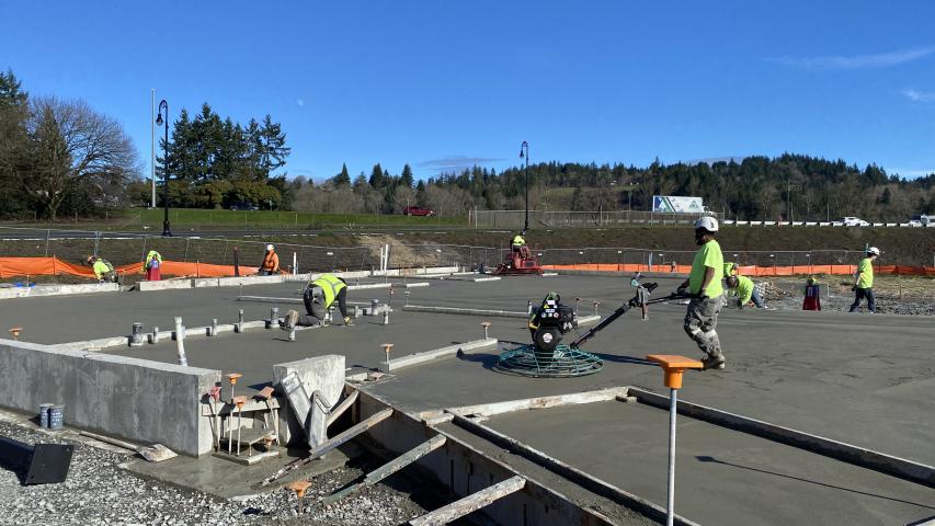 Construction workers pour the concrete for the floor of the future Woodland Community Library 