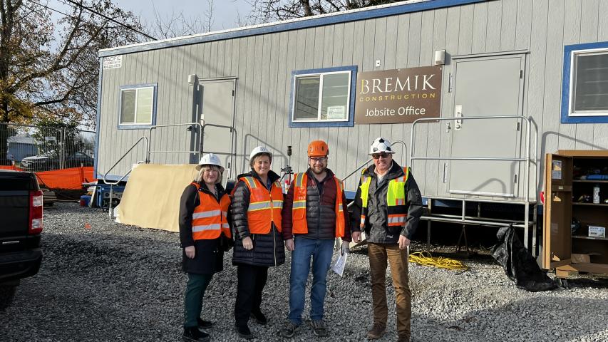 Executive Director Jennifer Giltrop and Woodland Community Library Branch Manager Jennifer Hauan stand with workers in front of the Bremik Construction jobsite office 