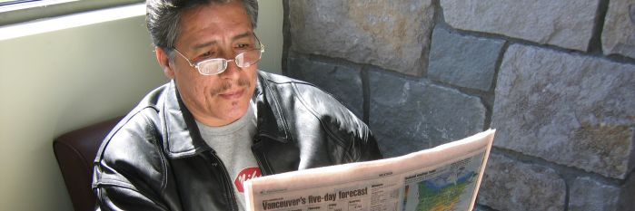 Man reading newspaper at Battle Ground Community Library