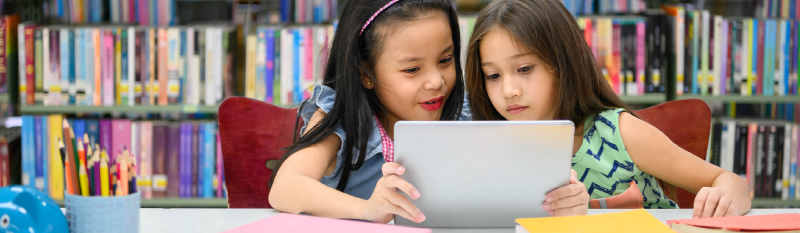 Two young girls in a library