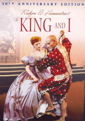 Red haired woman in hoop dress dances with bald man in crimson and gold Thai costume