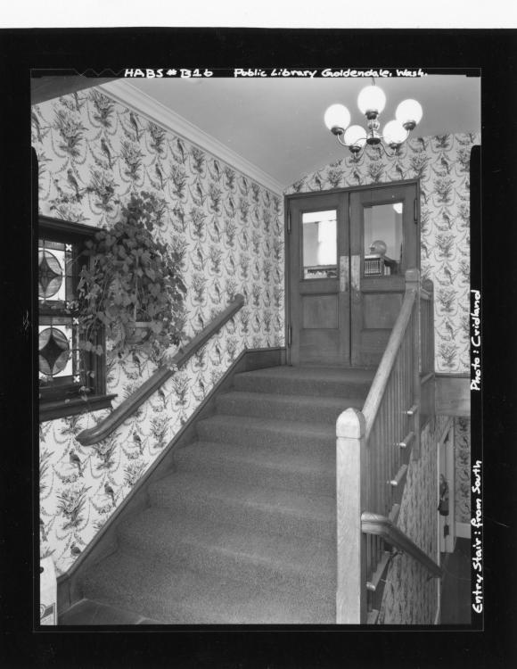Black-and-white photo of interior stairs leading to Goldendale Community Library, dated 3-20-1984