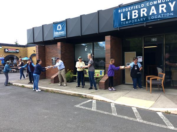 Volunteers pass books to the new Ridgefield Community Library, June 5, 2021.