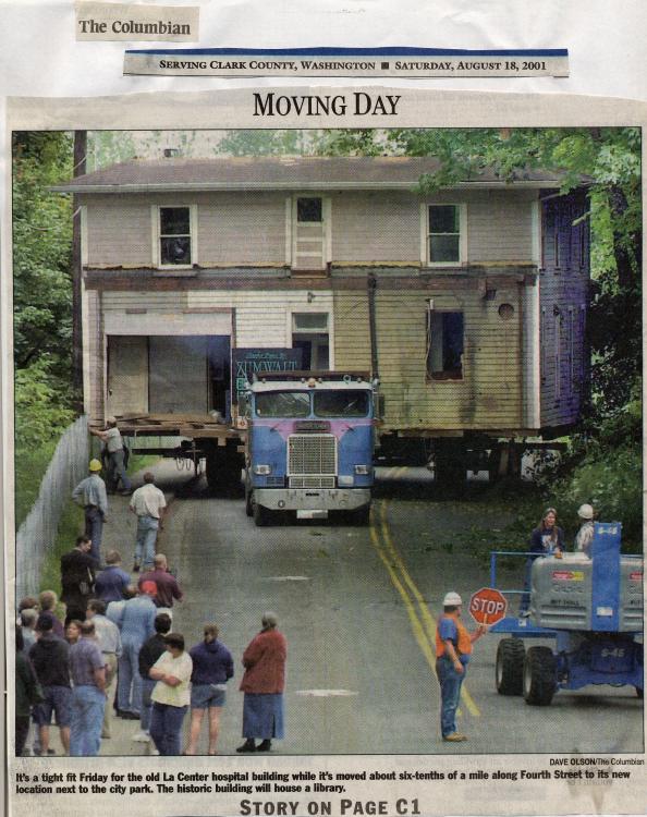 Photo of a newspaper article in the Columbian, dated August 18, 2001, about the move of the La Center hospital building in preparation for its becoming a library. Onlookers observe as the building is loaded onto a semi truck. 
