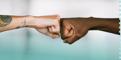 Two arms coming together in a fist bump